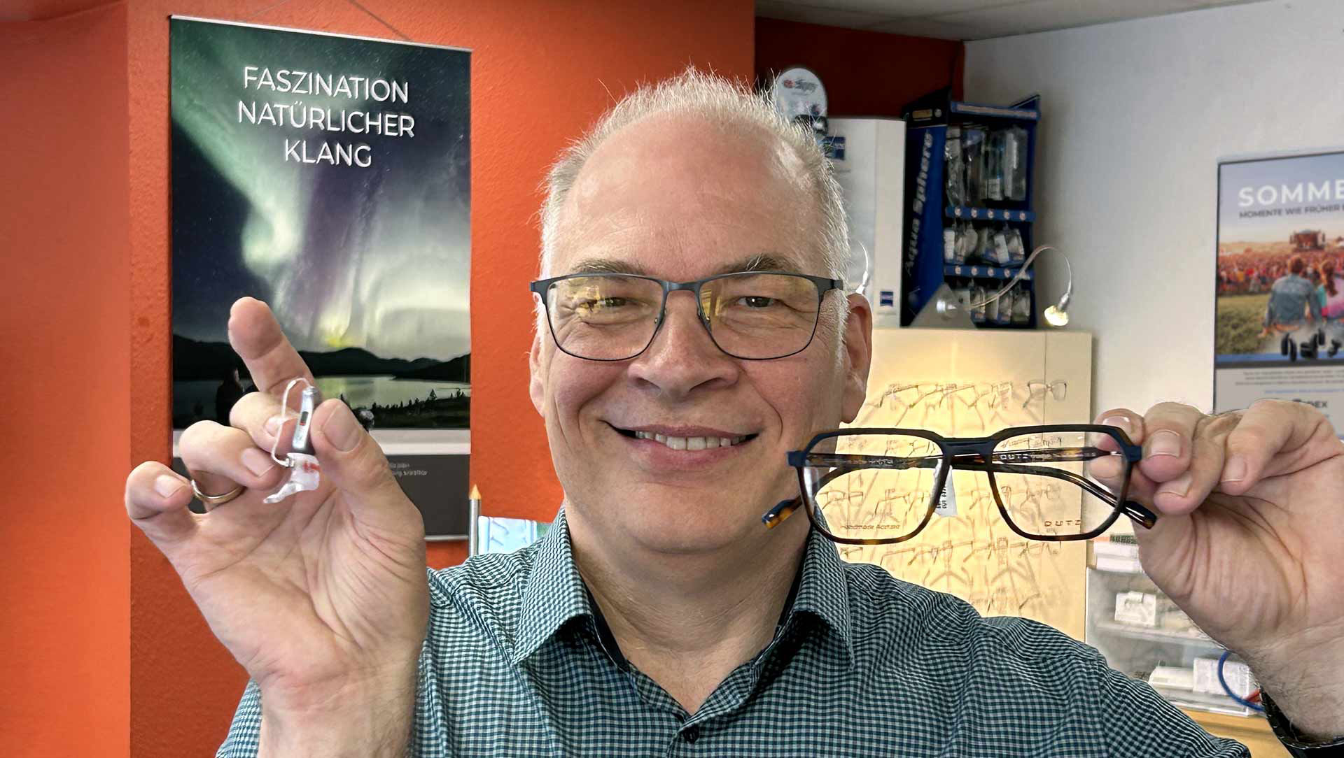 Heimers mit Hörgerät und Brille in den Händen